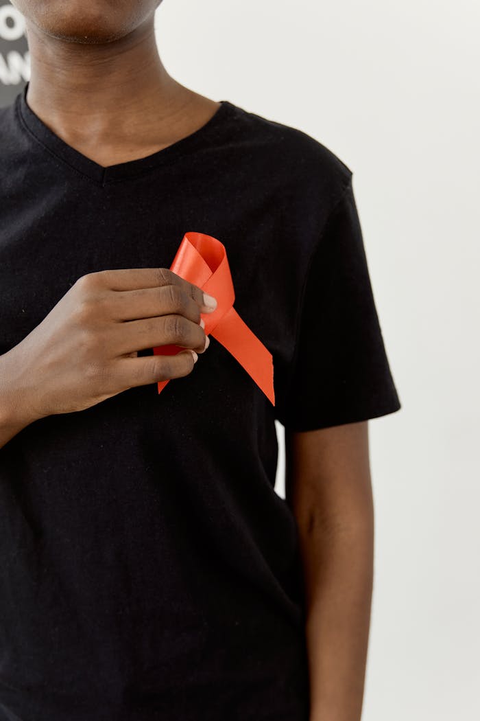 Close-up of a person with a red awareness ribbon symbolizing health awareness campaigns.
